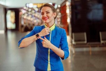 快乐的女人空姐指出智能手表机场