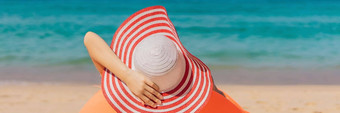 夏天生活方式肖像漂亮的女孩坐着橙色充气沙发海滩热带岛放松享受生活空气床上横幅长格式