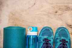 体育绿松石蓝色的阴影木背景瑜伽席体育运动鞋子运动服装瓶水概念健康的生活方式体育运动饮食体育运动设备复制空间