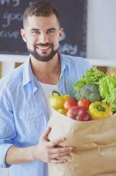 男人。持有纸袋完整的食品杂货厨房背景购物健康的食物概念