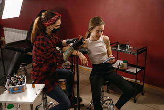 专业纹身艺术家保护面具使纹身女客户端