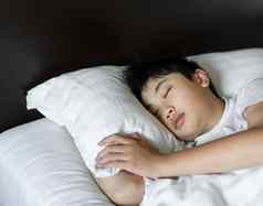 男孩睡眠床上卧室放松健康的概念