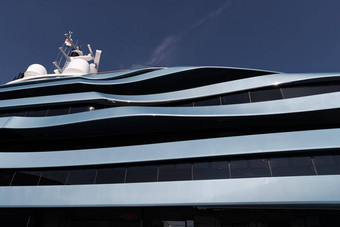 底视图甲板巨大的游艇蓝色的颜色阳光明媚的一天光滑的董事会电动机船太阳反射光滑的董事会蓝色的天空背景