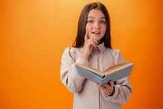 肖像聪明的青少年女孩书橙色背景