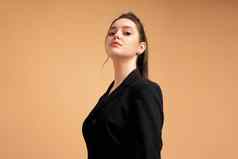 年轻的业务女人关闭肖像穿着黑色的夹克站工作室孤立的颜色背景