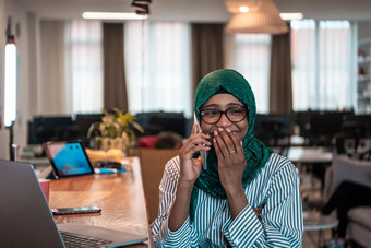 微笑年轻的女人说话智能手机工作移动PC距离思考快乐非洲美国客户客户端现代小工具手机电脑首页办公室
