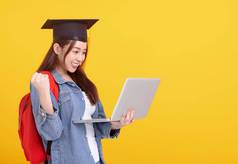 快乐亚洲女孩大学学生毕业帽持有移动PC