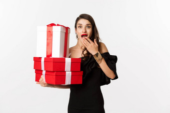 庆祝活动圣诞节假期概念女人持有圣诞节礼物惊讶收到礼物站白色背景