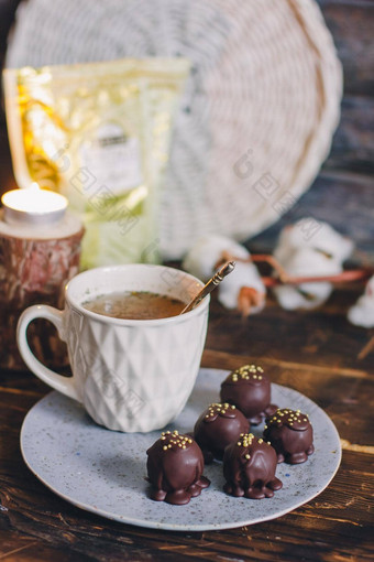 黑暗巧克力手工制作的糖果球手工制作的板黑暗木背景杯茶白色杯