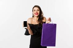 美购物概念美丽的时尚的女人显示移动电话屏幕袋购买在线站白色背景