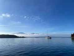 单帆船锚平静水蓝色的天空