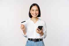 在线购物概念图像年轻的亚洲现代女人持有信贷卡智能手机购买智能手机应用程序支付非接触式站白色背景
