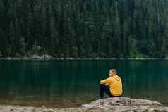 旅行者男人。放松冥想宁静视图山湖景观旅行生活方式徒步旅行概念夏天假期户外的家伙站山湖孤独的男人。之前美丽的视图山湖度假胜地