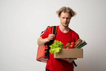 食物交付概念交付服务食品杂货市场首页快递红色的t恤热袋背包肩膀持有纸盒子有机食物产品