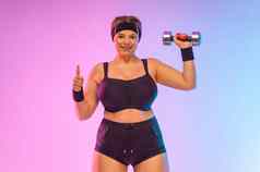 年轻的脂肪女人女运动员身体积极的健身女孩失去重量哑铃女孩显示指出Copyspace
