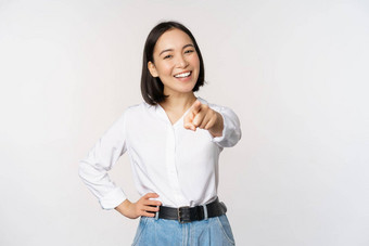 美丽的年轻的亚洲女人公司经理指出手指相机微笑选择邀请人招聘站白色背景