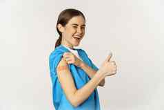 微笑护士医生实习医生风云医疗工人显示接种疫苗肩膀补丁拇指推荐接种疫苗冠状病毒白色背景