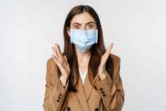 workaplce流感大流行概念震惊了业务女人脸医疗面具喘气吓了一跳有关相机站白色背景