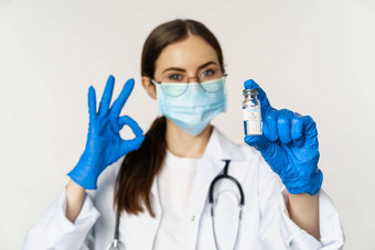 关闭肖像年轻的专业女人医生医生医疗脸面具眼镜显示疫苗批准推荐接种疫苗新冠病毒