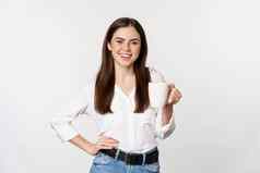 年轻的莫德业务女人办公室夫人持有杯子咖啡茶微笑站白色背景