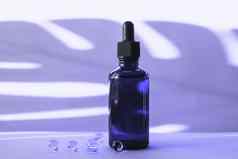 血清瓶维生素胶囊紫色的背景棕榈叶影子颜色一年仙女概念皮肤护理