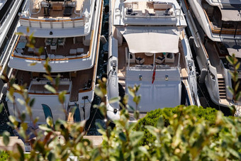 巨大的停泊游艇港口赫拉克勒摩纳哥阳光明媚的一天基督山卡 罗内饰电动机船令人心寒的区巨型游艇视图绿色分支机构树太阳反射