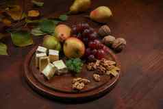 酒零食集奶酪葡萄梨核桃木表格布里干酪奶酪水果葡萄核桃黑暗木板木董事会