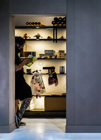 一边视图年轻的亚洲男人。穿脸面具聪明的电话打字文本消息站前面白色墙艺术画廊展览房间