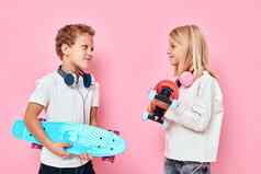 时尚的男孩可爱的女孩耳机滑板手活跃的生活方式童年