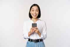 兴奋亚洲女人微笑反应信息移动电话持有智能手机快乐相机站白色背景