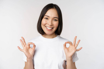 优秀的微笑亚洲女人显示标志批准手势满意推荐smth站白色背景