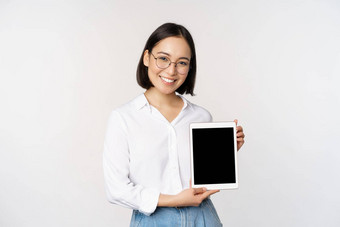 年轻的亚洲女人专业演示了数字平板电脑屏幕信息小工具微笑相机站白色背景