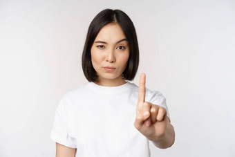 图像亚洲女孩显示停止禁止smth扩展手臂显示禁止禁忌手势站T恤白色背景