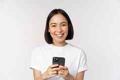 肖像微笑亚洲女人移动电话聊天发短信消息站T恤白色背景