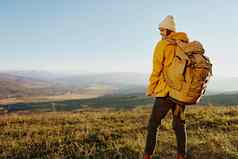 女人旅行者黄色的夹克他背包旅行山新鲜的空气
