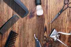 饱经风霜的木表面理发师工具古董手册头发限幅器库姆斯剃须刀美容剪刀前视图平躺
