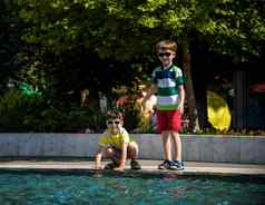 集团快乐孩子们玩在户外池喷泉孩子们有趣的公园夏天假期穿着色彩斑斓的t恤短裤太阳镜夏天假期概念