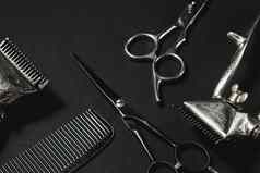 黑色的表面理发师工具古董手册头发限幅器梳子美容剪刀黑色的单色对比阴影前视图平躺