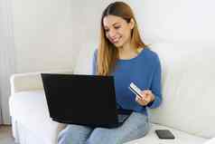 巴西美丽的女孩购物在线信贷卡移动PC坐着沙发首页