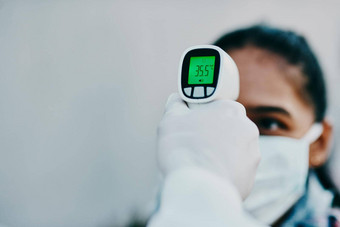 切割边缘科技抑制传播拍摄年轻的女人温度红外温度计医疗保健工人爆发