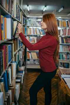 女孩持有书架子上学生图书馆