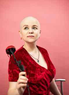 肖像秃女人癌症化疗红色的袍人工玫瑰花