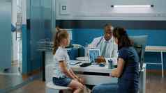 医生持有平板电脑显示射线照相法诊断妈妈。孩子