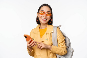 时尚的年轻的亚洲女人旅游旅行者背包智能<strong>手机</strong>微笑相机摆姿势白色背景