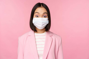 肖像亚洲女商人医疗脸面具穿西装概念办公室工作科维德流感大流行站粉红色的背景
