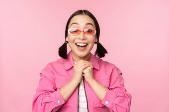 肖像兴奋日本女孩太阳镜庆祝实现目标喘气惊讶微笑站粉红色的背景