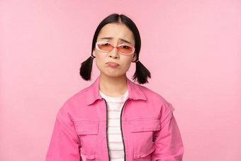 肖像伤心悲观的亚洲女孩生闷气的失望站心烦意乱粉红色的工作室背景