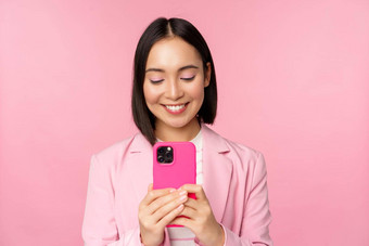 肖像微笑业务女人亚洲企业人智能手机移动电话应用程序站粉红色的背景