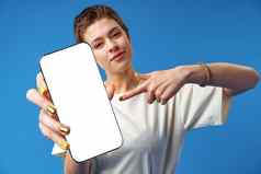 肖像年轻的女人显示空白屏幕移动电话站蓝色的背景
