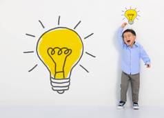 孩子学生思考光灯泡白色墙可爱的男孩的想法创新技术教育概念